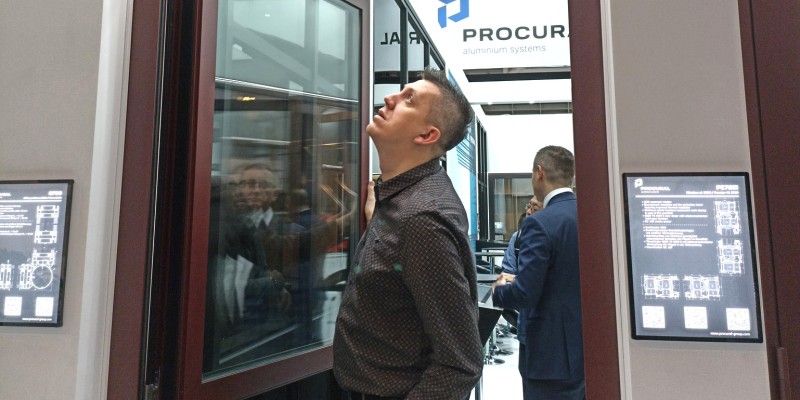 Mann begutachtet ein PROCURAL Fenster auf der BAU 2025