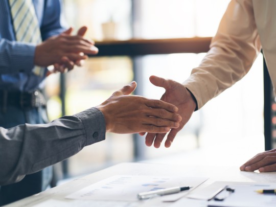 Business men almost shaking hands