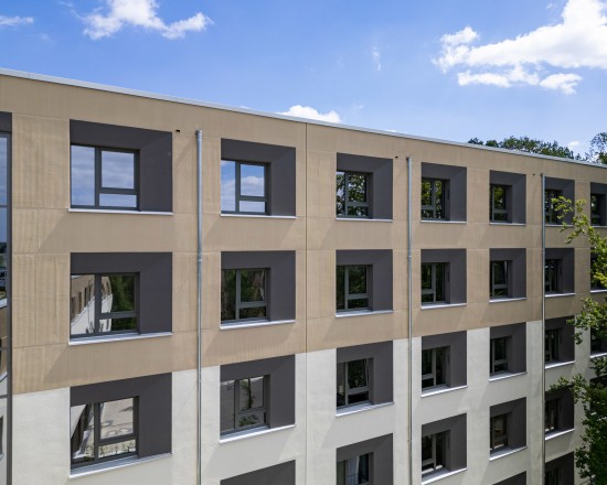 Die Fensterprofil-Oberfläche VEKA Feinstruktur im Farbton quarzgrau ist Teil der Fassadengestaltung des neuen Studierendenwohnheims Golm 2 in Potsdam. Durch den schräg in die Dämmung laufenden Putz entsteht eine schattierende Wirkung.