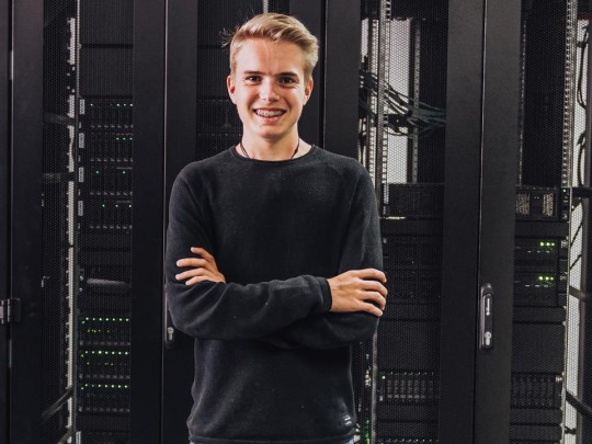 IT Azubi vor den Serverschränken