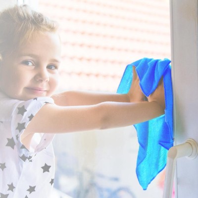 Kleines Mädchen putzt Fenster