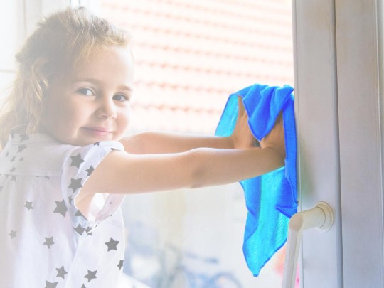 Small girl cleaning window