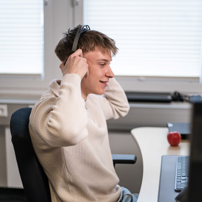 Trainee in front of a computer putting a headset on