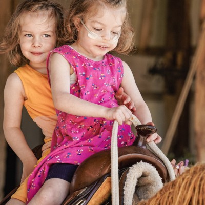 Two girls riding a horse